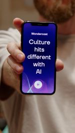 Iemand houdt een telefoon vast. Op het scherm staat: Culture hits different with AI