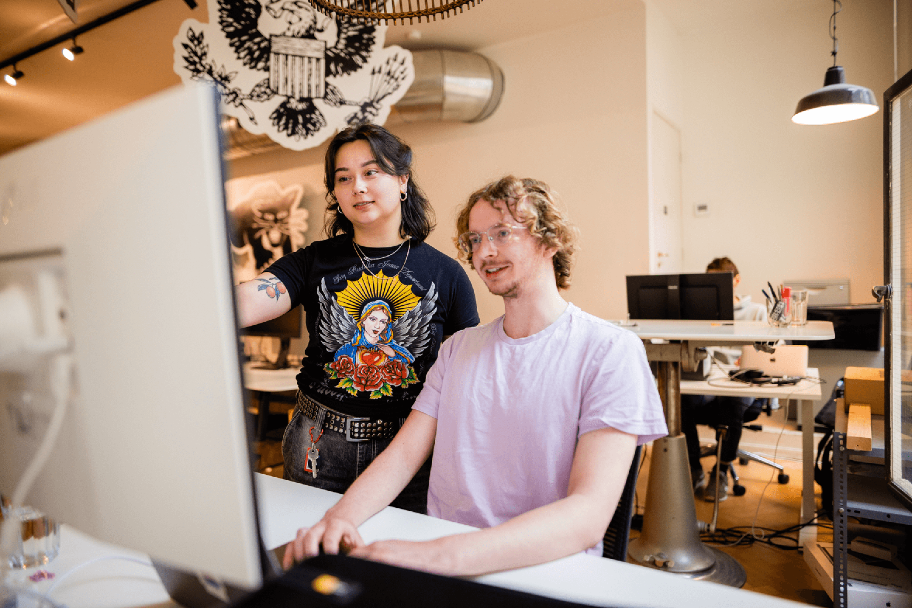 Een man en een vrouw staan samen bij een computerscherm