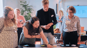 Meerdere mensen, man en vrouwen, kijken naar post-it notes en zijn een strategie aan het doornemen, co-creatie