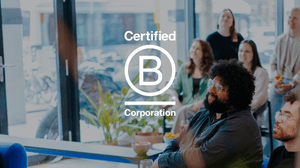 Mensen kijken naar een presentatie. Over de foto staat een B Corp logo