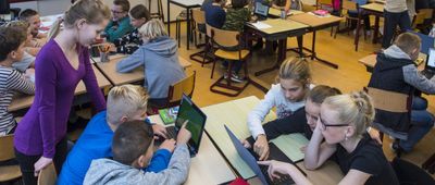 Kinderen in een klaslokaal kijken naar een laptopscherm