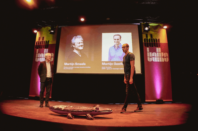 Twee mannen staan samen op een podium
