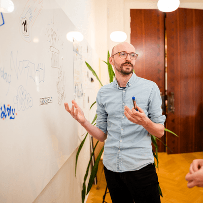 Man legt iets uit terwijl hij voor een whiteboard staat, strategie