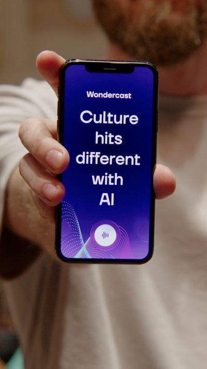 Iemand houdt een telefoon vast. Op het scherm staat: Culture hits different with AI