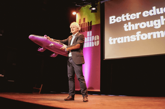 Man staat op een podium met een paarse krokodil in zijn hand